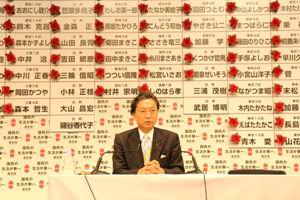 DPJ leader Senator Yukio Hatoyama, PhD in front of the election board with red rossetes on winning districts